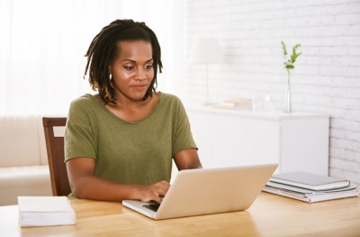 03-20-Womaningreenoncomputer-iStock-998633398