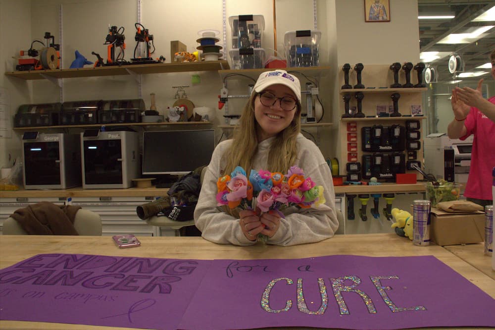 Recycled flower art creator showing her project.