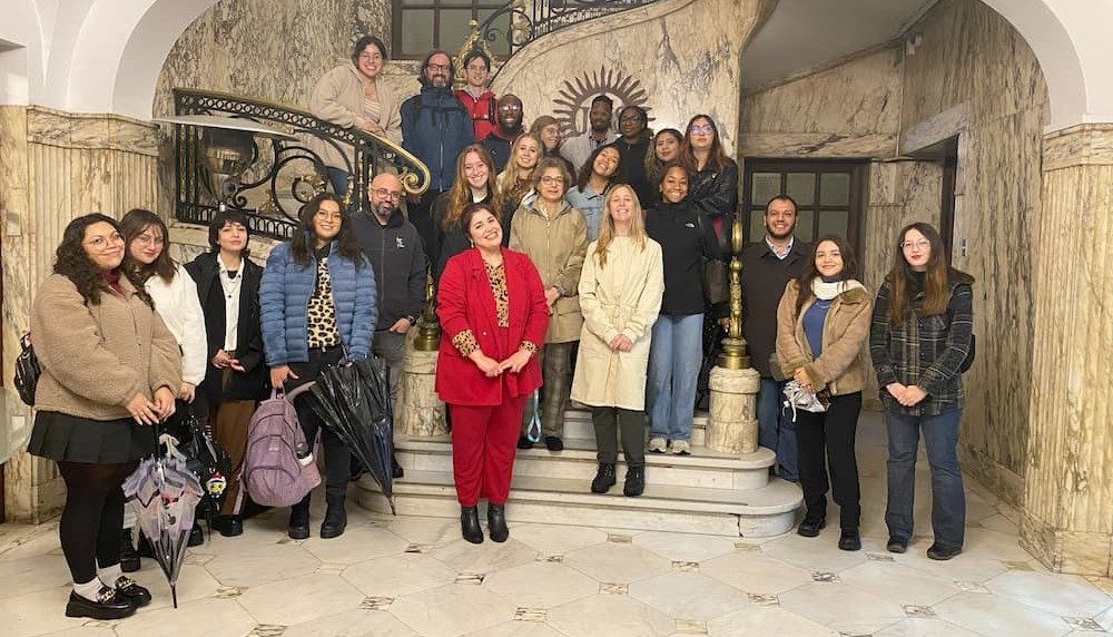 Group of adults posing on a marble staircase.