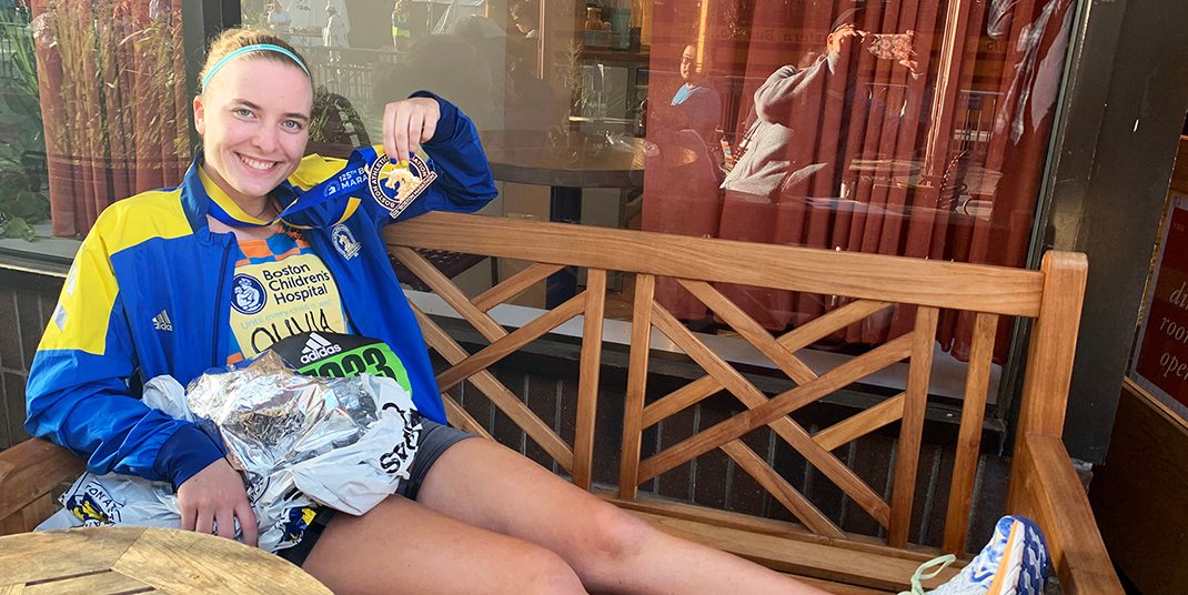 Olivia Colombo sitting on a bench holding a medal