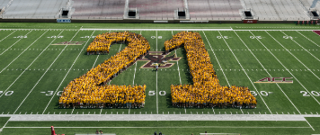 Class of 2021 on the BC football field wearing yellow SuperFan shirts