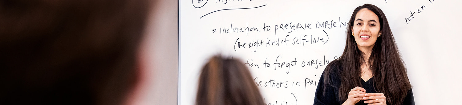 A professor standing in front of a white board