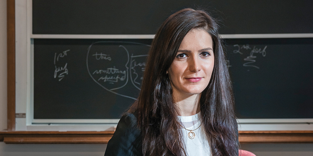 Hristina Nikolova poses in front of a chalkboard in a classroom