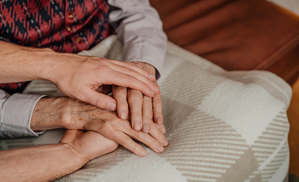 A caregiver comforts and older man