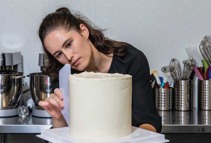 Photo of Ilona Znakharchuck ’21 holding one of her beautifully decorated cakes