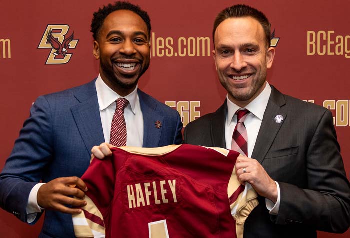 Martin Jarmond and Jeff Hafley both holding a football jersey with Hafley's name the back.