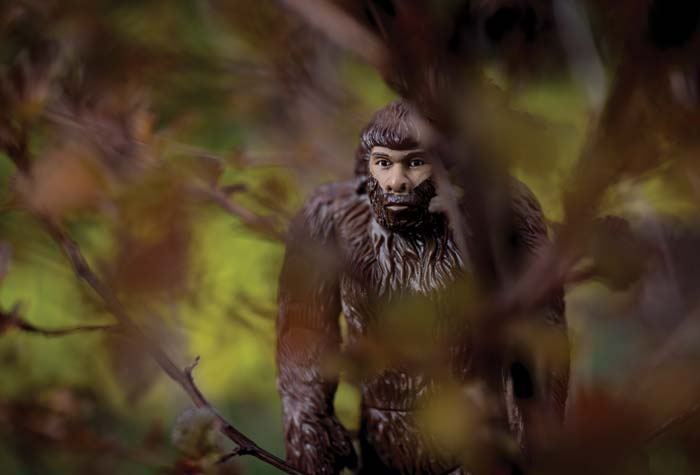 A Bigfoot toy in a mock forest setting.