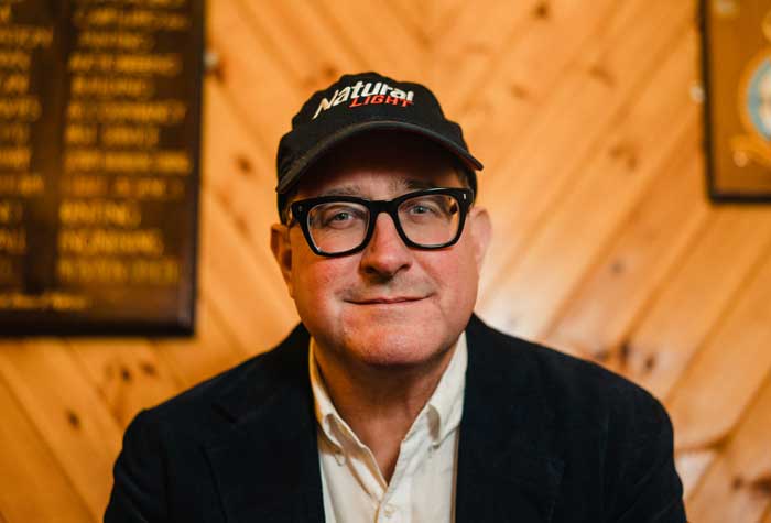 Craig Finn photographed seated on a couch.