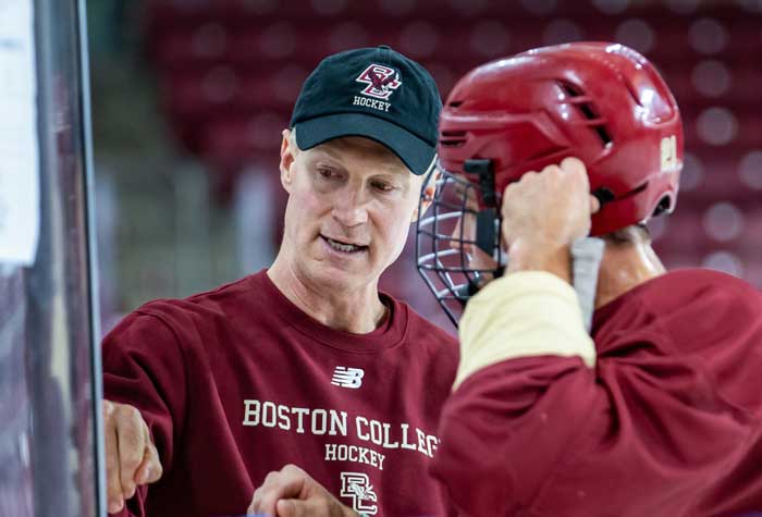 Coach Greg Brown coaching on ice with players.