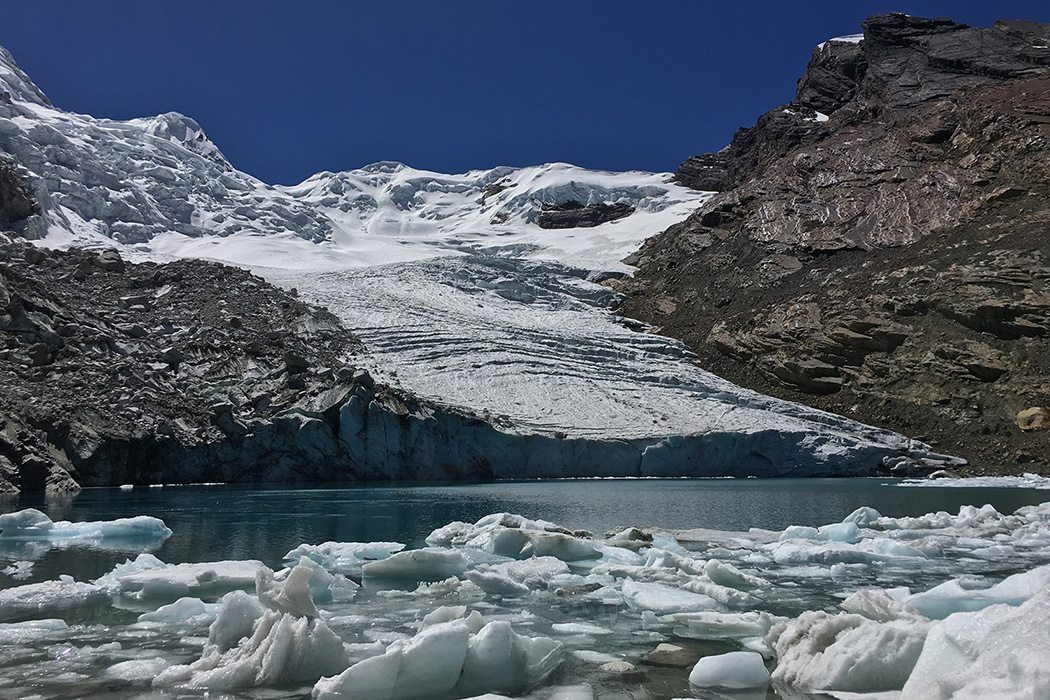 Snow covered mountains behind melted glacial ice