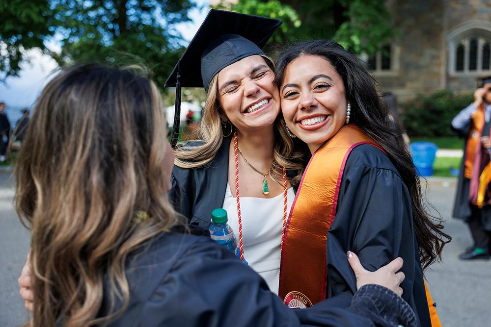 Three people smiling at commencement