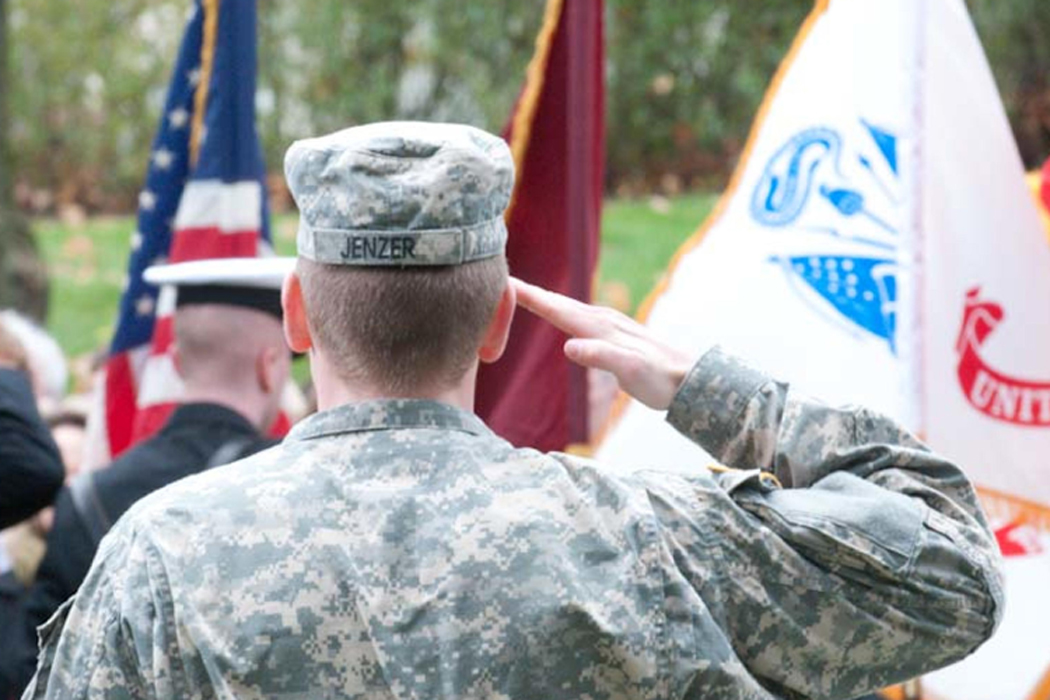 rear view of a man in uniform saluting