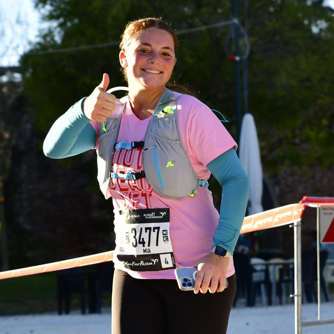 A woman running and holding her thumb up