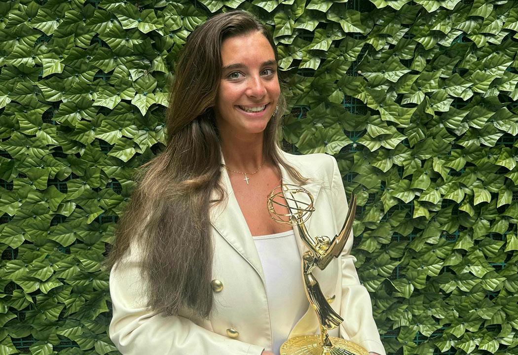 A woman holding a gold trophy