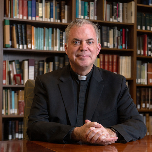 Casey Beaumier, S.J., Director, Institute for Advanced Jesuit Studies and Vice President & University Secretary photographed in an IAJS library in Simboli Hall.