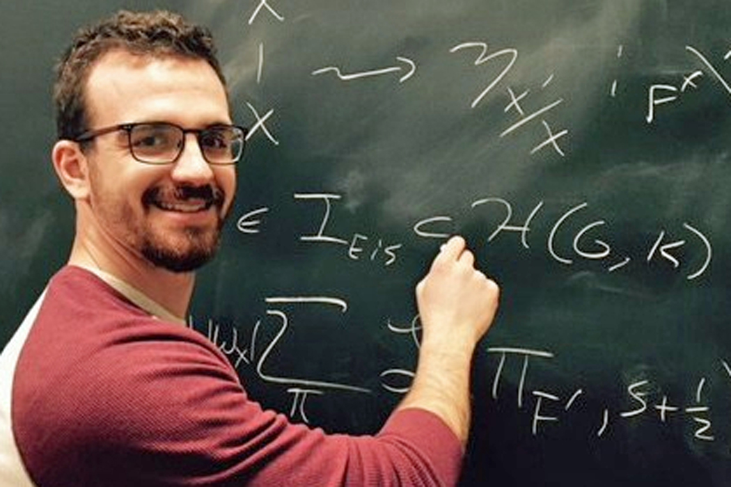 Spencer Leslie writing an equation on a chalkboard