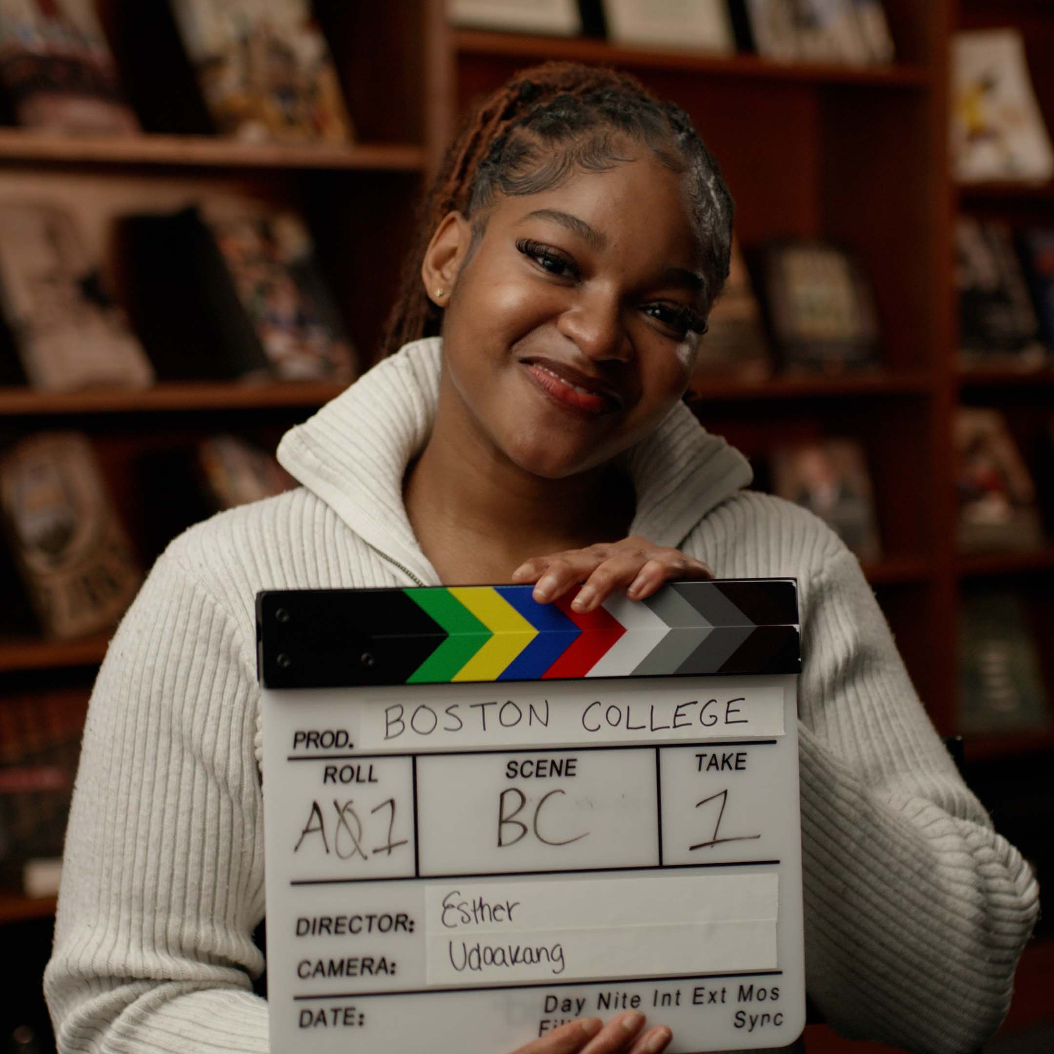 Esther Udoakang holding a video clapboard
