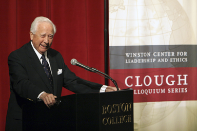 David McCullough speaking at a podium with a Clough Colloquium Series banner behind him